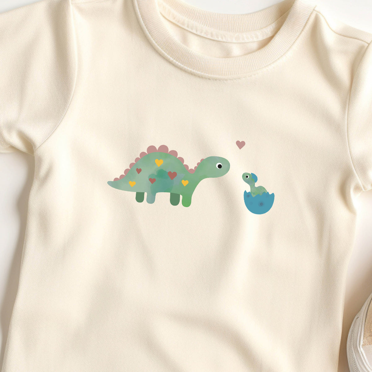 Bügelbild mit Dino-Mama und Baby im niedlichen Design, ideal zum Aufbügeln auf Kinderkleidung und Accessoires.