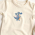 Bügelbild mit blauem Drachen im verspielten Wunderland-Design, perfekt zum Aufbügeln auf Kinderkleidung und Accessoires.