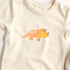 Bügelbild mit orange-gelben Triceratops im kindlichen Design, perfekt zum Aufbügeln auf Kinderkleidung und Accessoires.