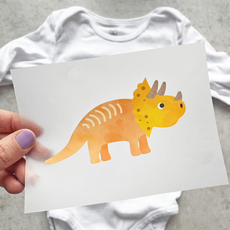 Bügelbild mit orange-gelben Triceratops im kindlichen Design, perfekt zum Aufbügeln auf Kinderkleidung und Accessoires.