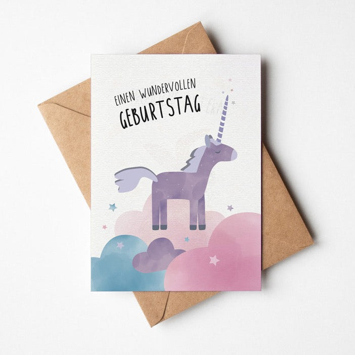 Postkarte mit einem Einhorn, dass auf rosa Wolken steht und von Sternen umgeben ist