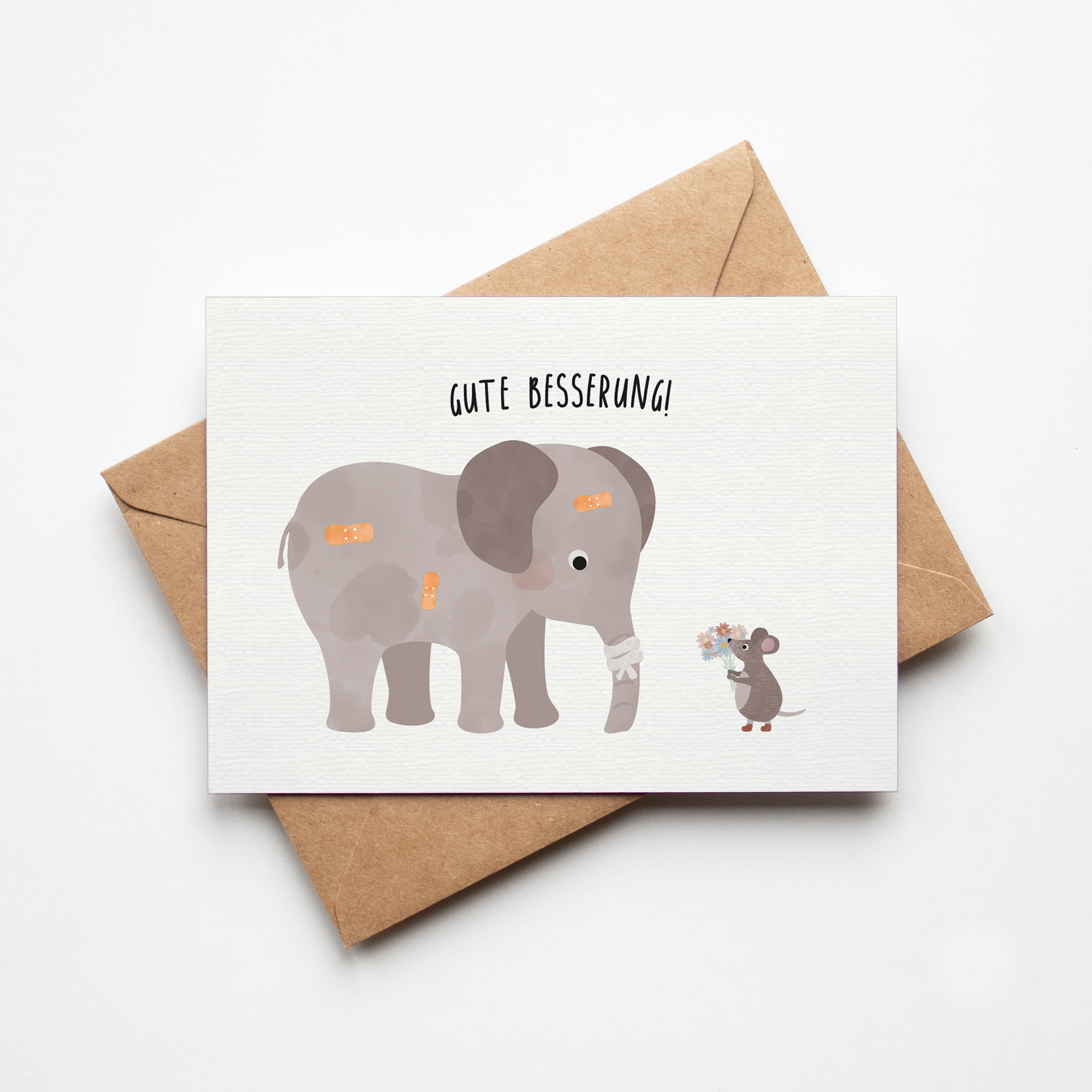 Grußkarte mit der Illustration eines Kuscheltiers im Krankenbett und dem Text „Gute Besserung“ auf hellem Hintergrund