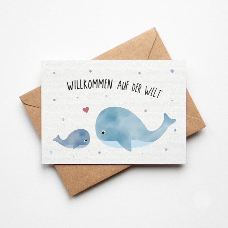 Postkarte mit Wal und dem Schriftzug „Willkommen auf der Welt“ im niedlichen Design, ideal als Geburtskarte oder Willkommensgruß für Babys.
