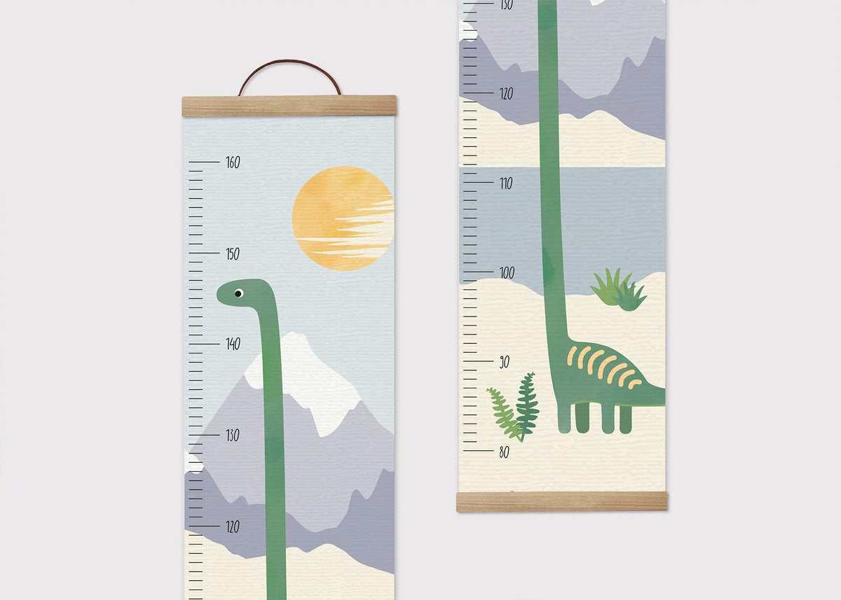 Zwei Messlatten mit Dino-Motiven. Die linke zeigt einen grünen Dinosaurier vor Bergen und einer Sonne, skaliert bis 160 cm. Die rechte zeigt den Dinosaurier seitlich mit Pflanzen im Hintergrund, ebenfalls skaliert bis 160 cm.