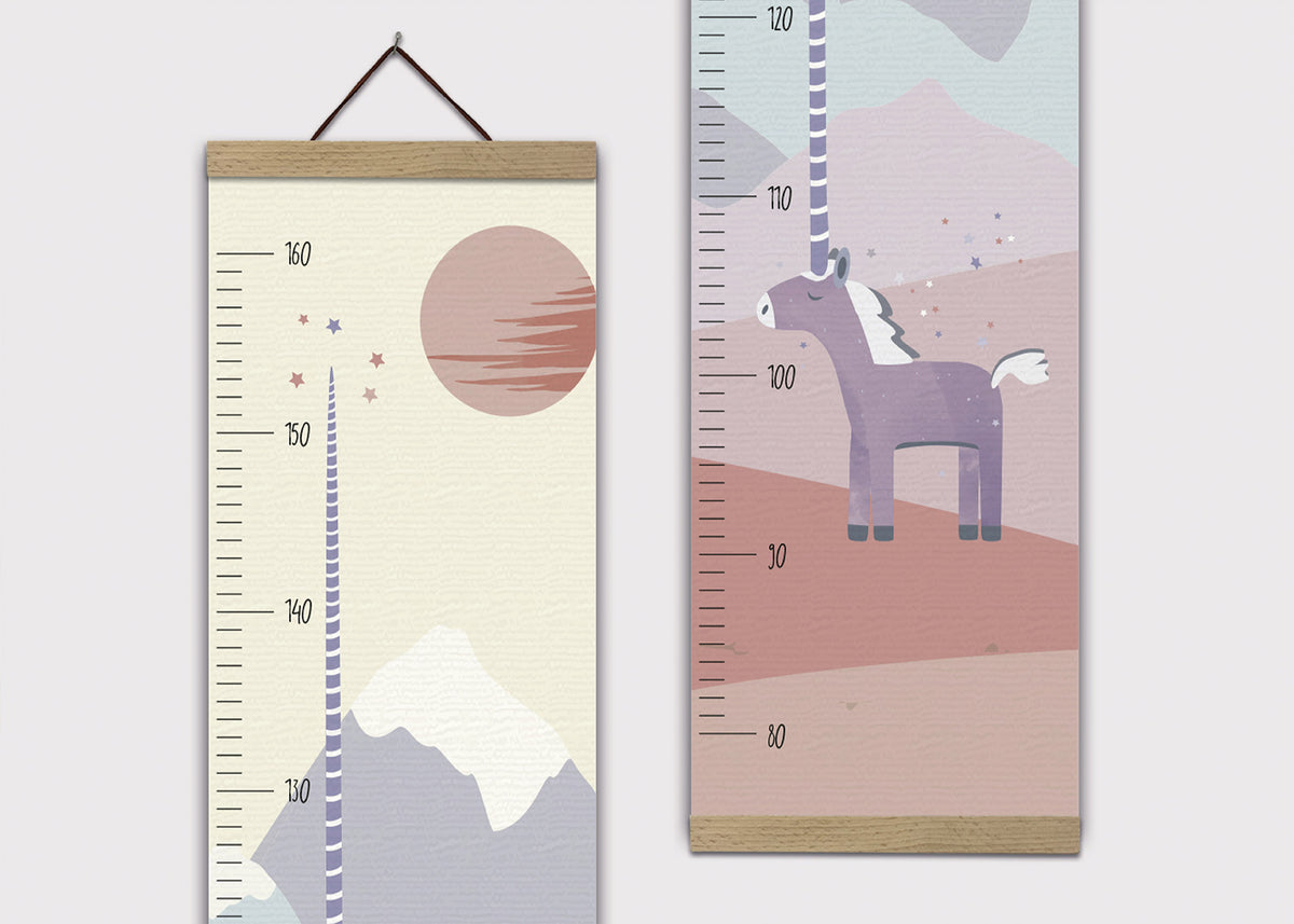 Zwei Kinderwachstumsdiagramme, die nebeneinander gezeigt werden. Das linke Diagramm hat eine Berglandschaft mit einem großen rosa Sonnenuntergang und kleinen Sternen darauf. Es enthält eine Messskala von 80 cm bis 160 cm. Das rechte Diagramm zeigt ein lila Einhorn mit einem langen Horn in einem farbenfrohen, abstrakten Hintergrund. Auch hier ist eine Messskala von 80 cm bis 160 cm vorhanden.