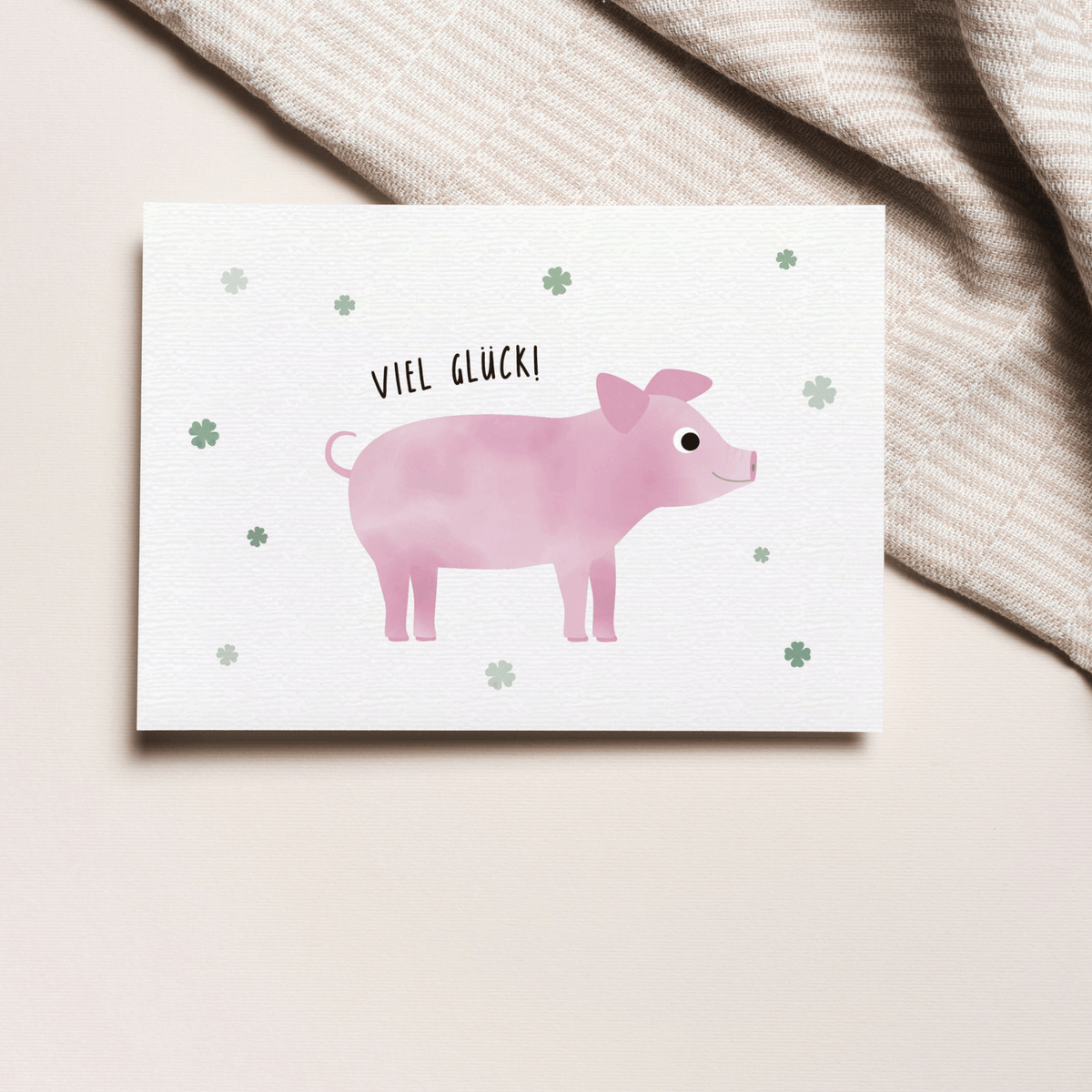 Grußkarte mit der Illustration eines rosa Glücksschweins und dem Text „Viel Glück“ auf hellem Hintergrund