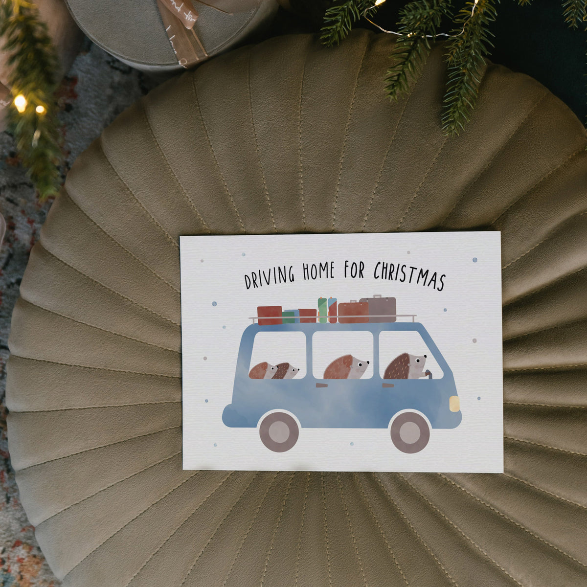 Postkarte mit Igel-Familie im Auto und dem Schriftzug „Driving home for Christmas“ im niedlichen Design, ideal als Weihnachtskarte oder kleiner Gruß.