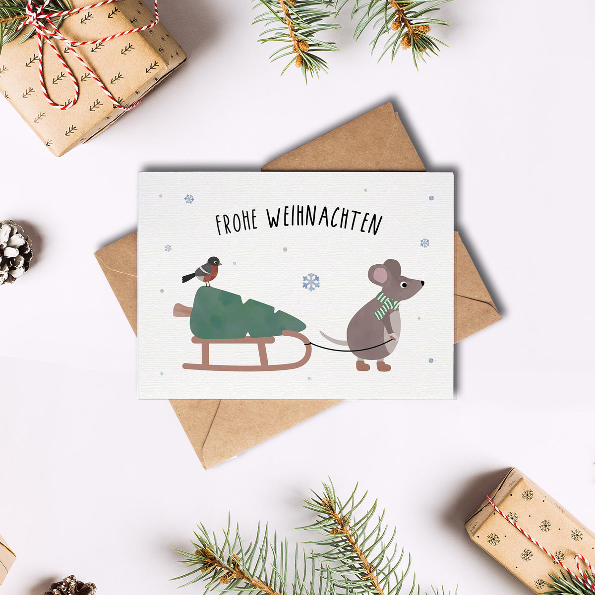Postkarte mit Maus, die einen Schlitten zieht, und dem Schriftzug „Frohe Weihnachten“ im niedlichen Winterdesign, ideal als Weihnachtskarte oder kleiner Gruß.