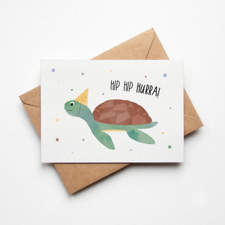 Jubelnde Schildkröte auf einer Karte, die voller Freude und Begeisterung "Hip Hip Hurra!" ausruft.