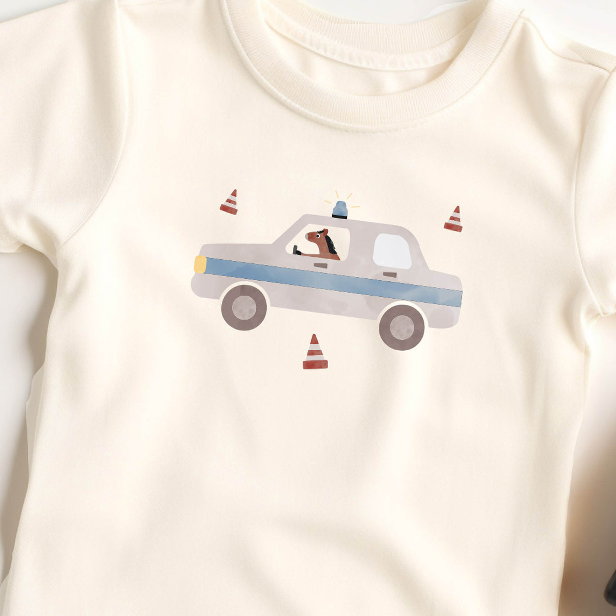 Bügelbild mit der Illustration eines Polizeiautos in dem ein Pferd sitzt