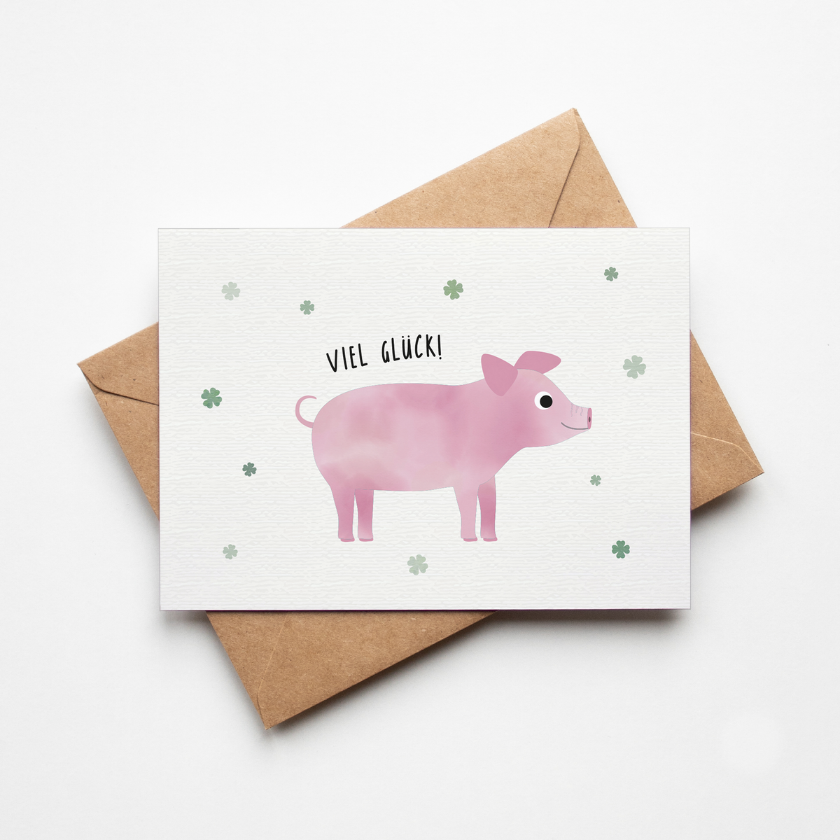 Grußkarte mit der Illustration eines rosa Glücksschweins und dem Text „Viel Glück“ auf hellem Hintergrund