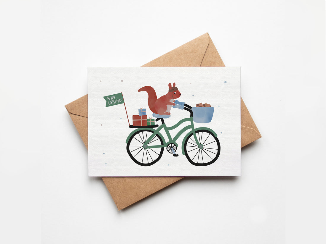 Weihnachtskarte mit Eichhörnchen auf einem Fahrrad mit Geschenken und dem Schriftzug „Merry Christmas“ im niedlichen Design, ideal als Weihnachtskarte oder kleiner Gruß.